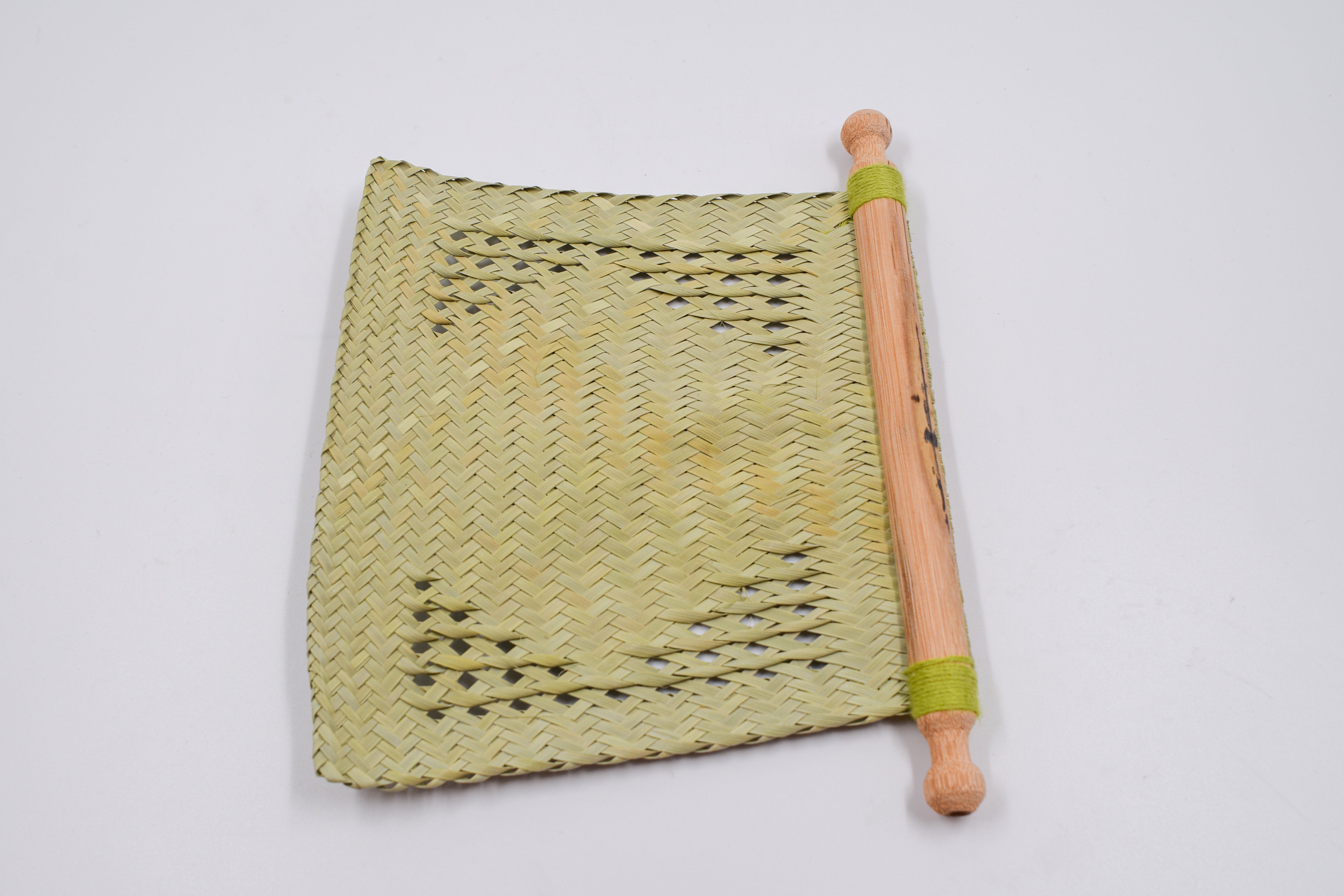 Éventail artisanal en feuilles et bois de palmier